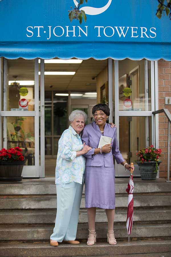 About St. John Towers - Two senior ladies in front of St John Towers