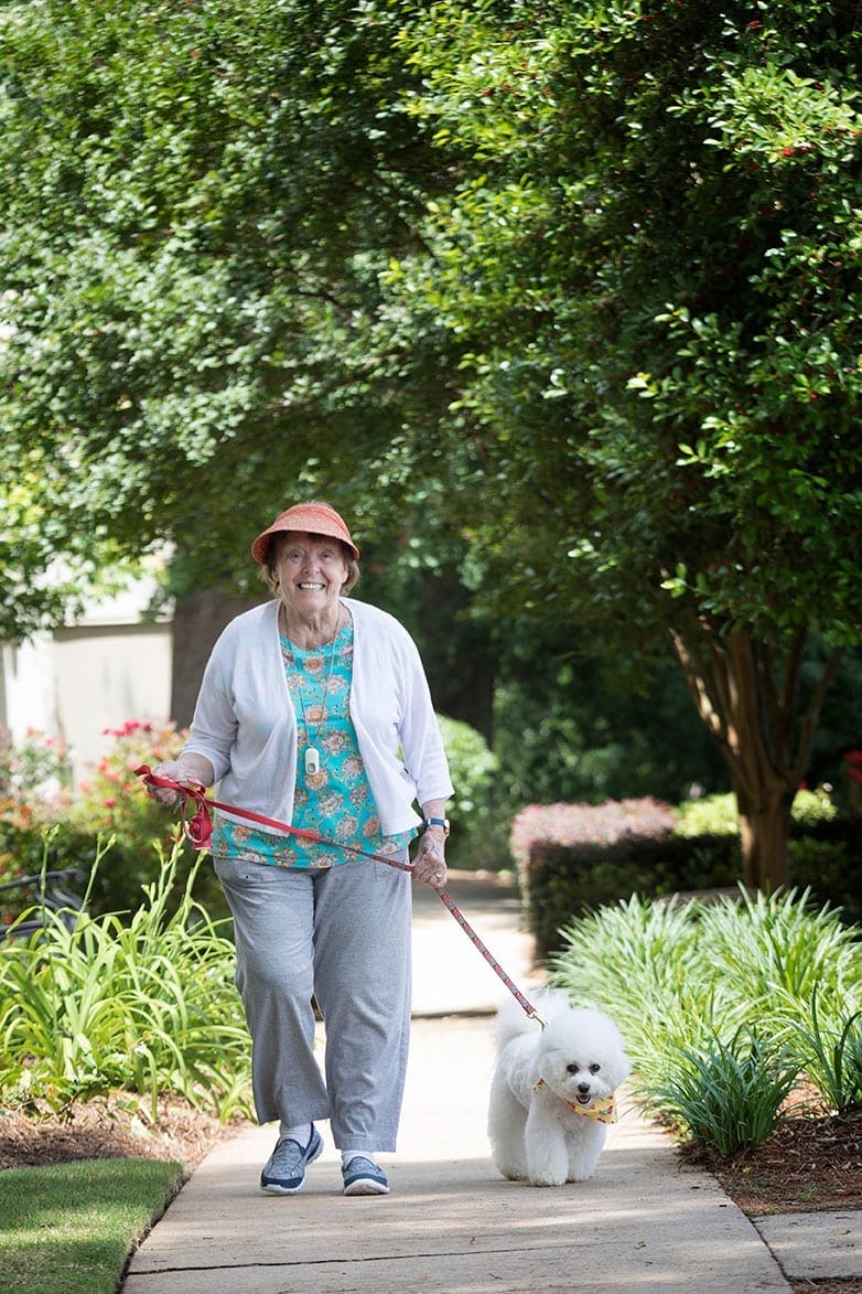 Senior woman walking her dog - about lanier gardens - lanier-gardens-about-page